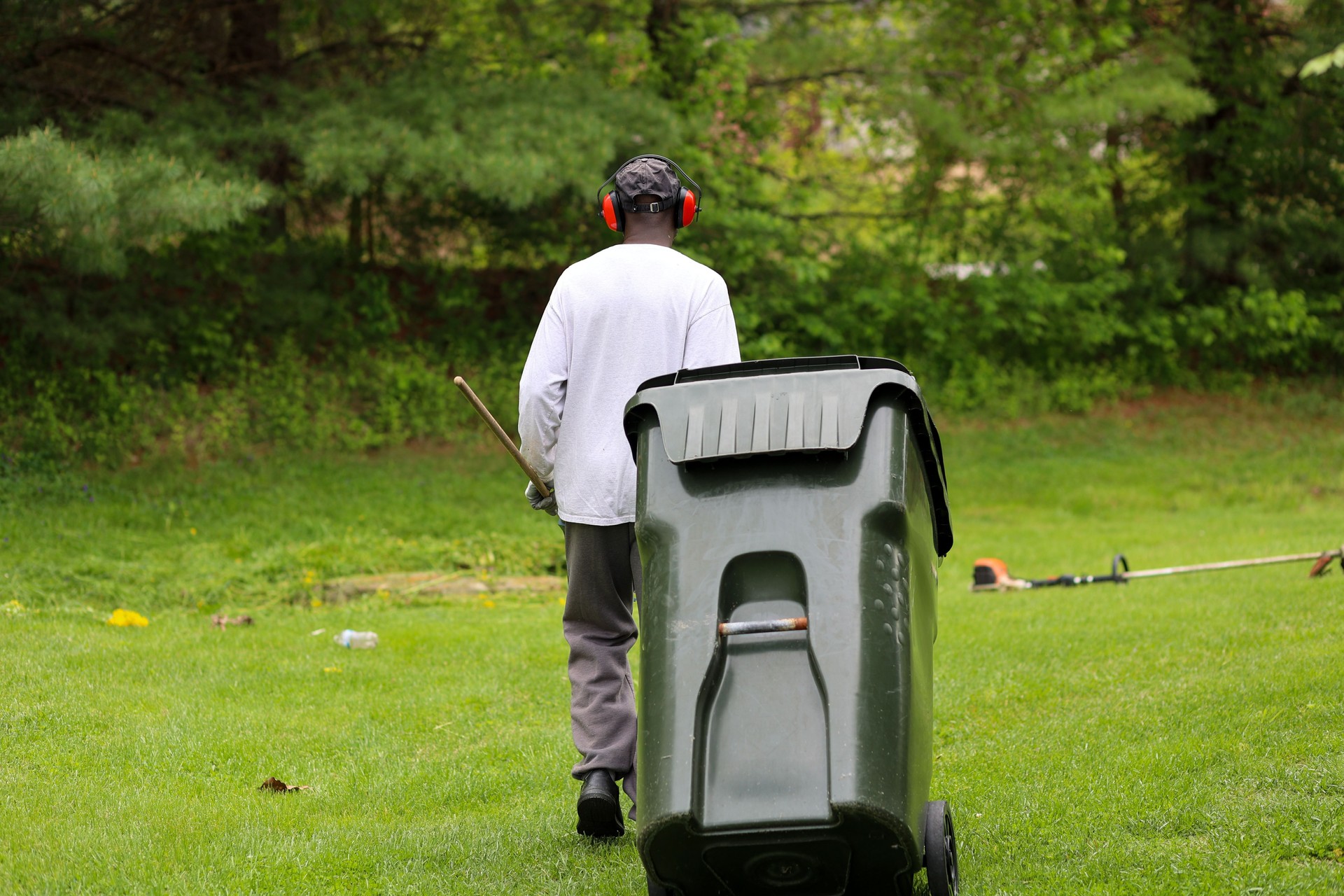 A portrait of a black man cleaning up in a park